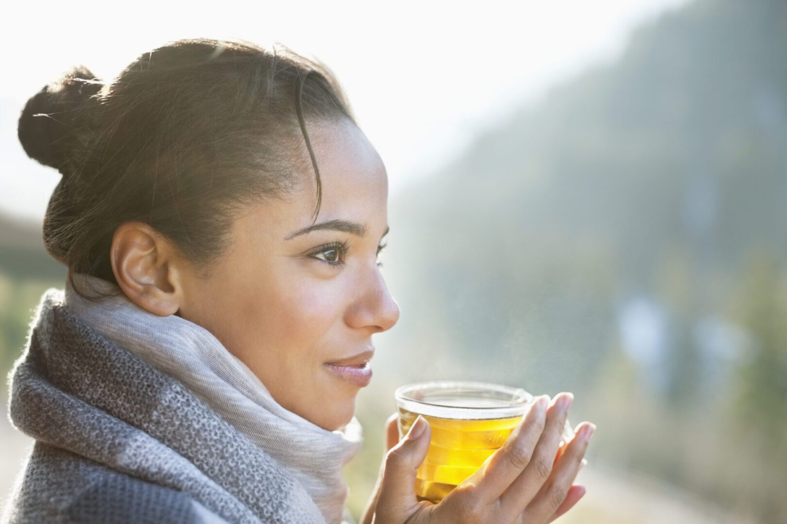 Close up of smiling woman drinking tea outdoors