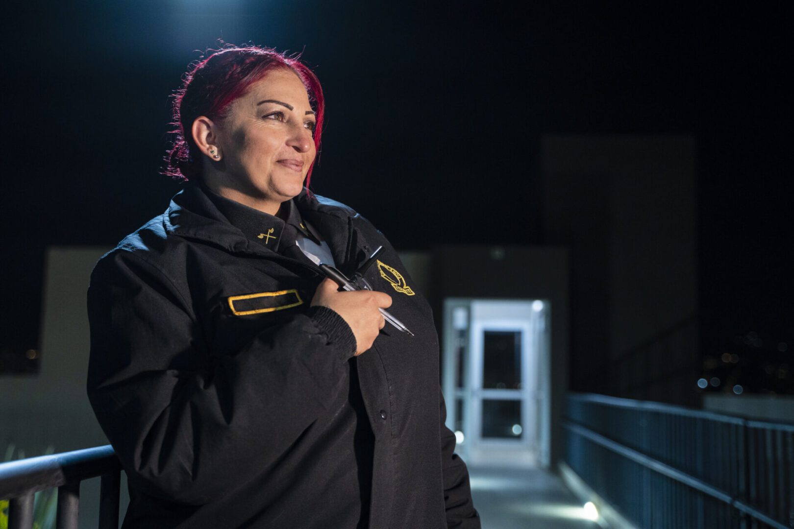 Happy woman working as security guard with radio and tablet for surveillance, investigation or navigation, communicating with her colleagues via radio to report the status of the work station