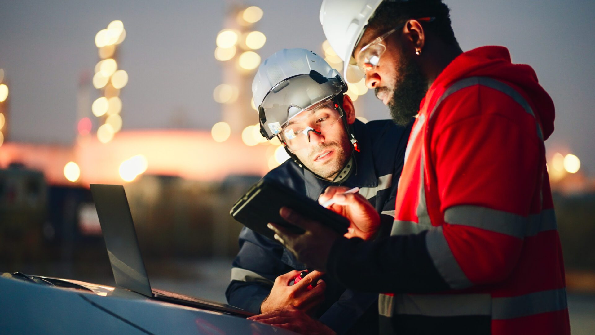 Team Inspection engineers working with laptop of oil factory and gas refinery plant industry at night for inspector safety quality control.