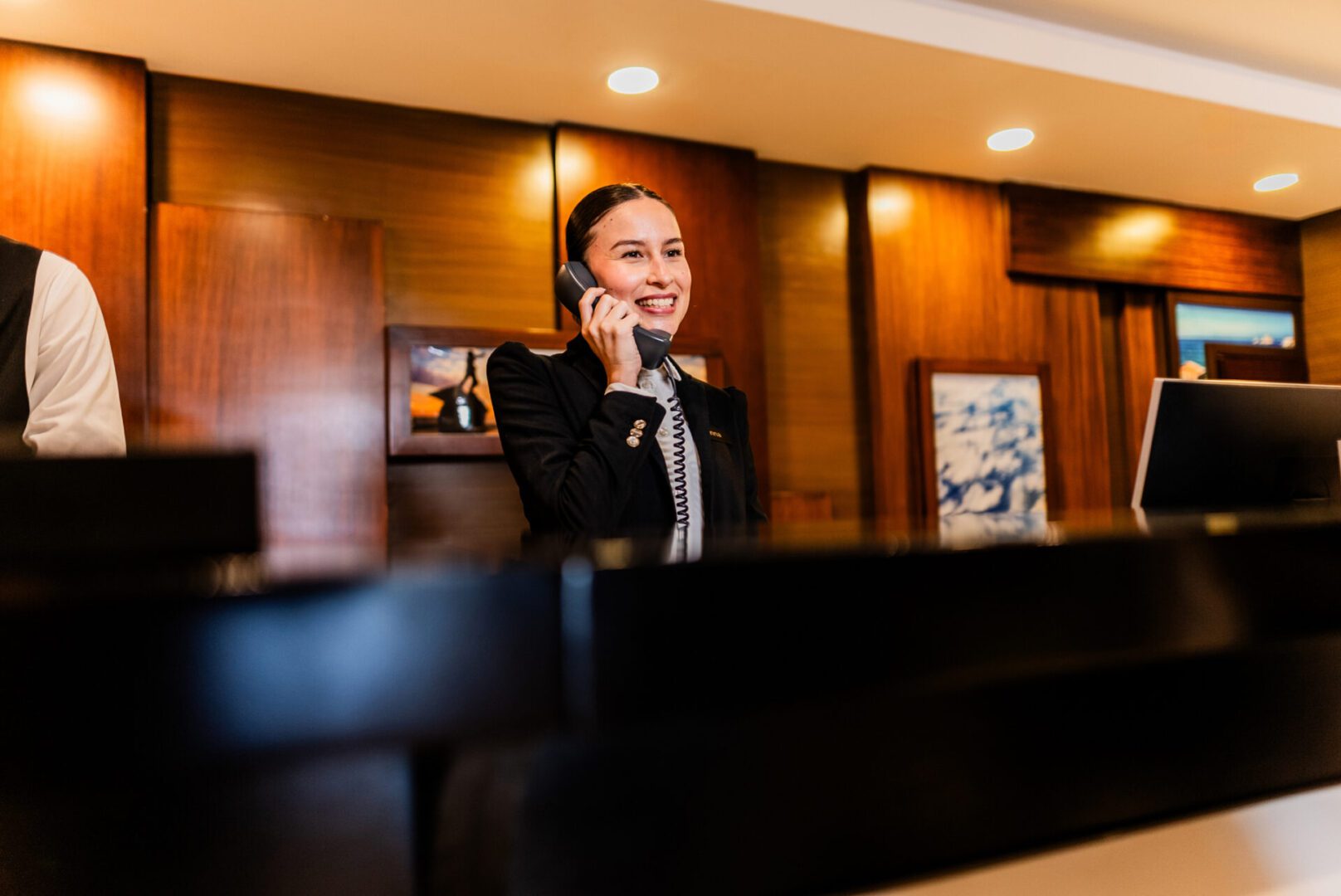 Young receptionist woman talking on telephone at hotel